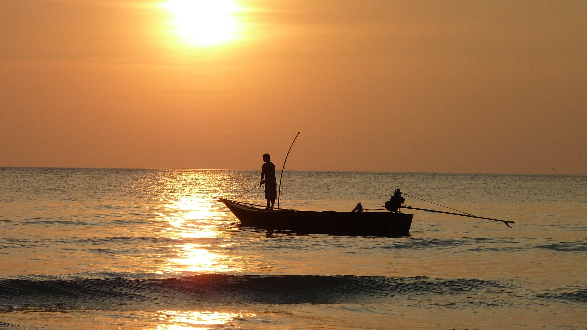 fishing boat in ocean at sunset