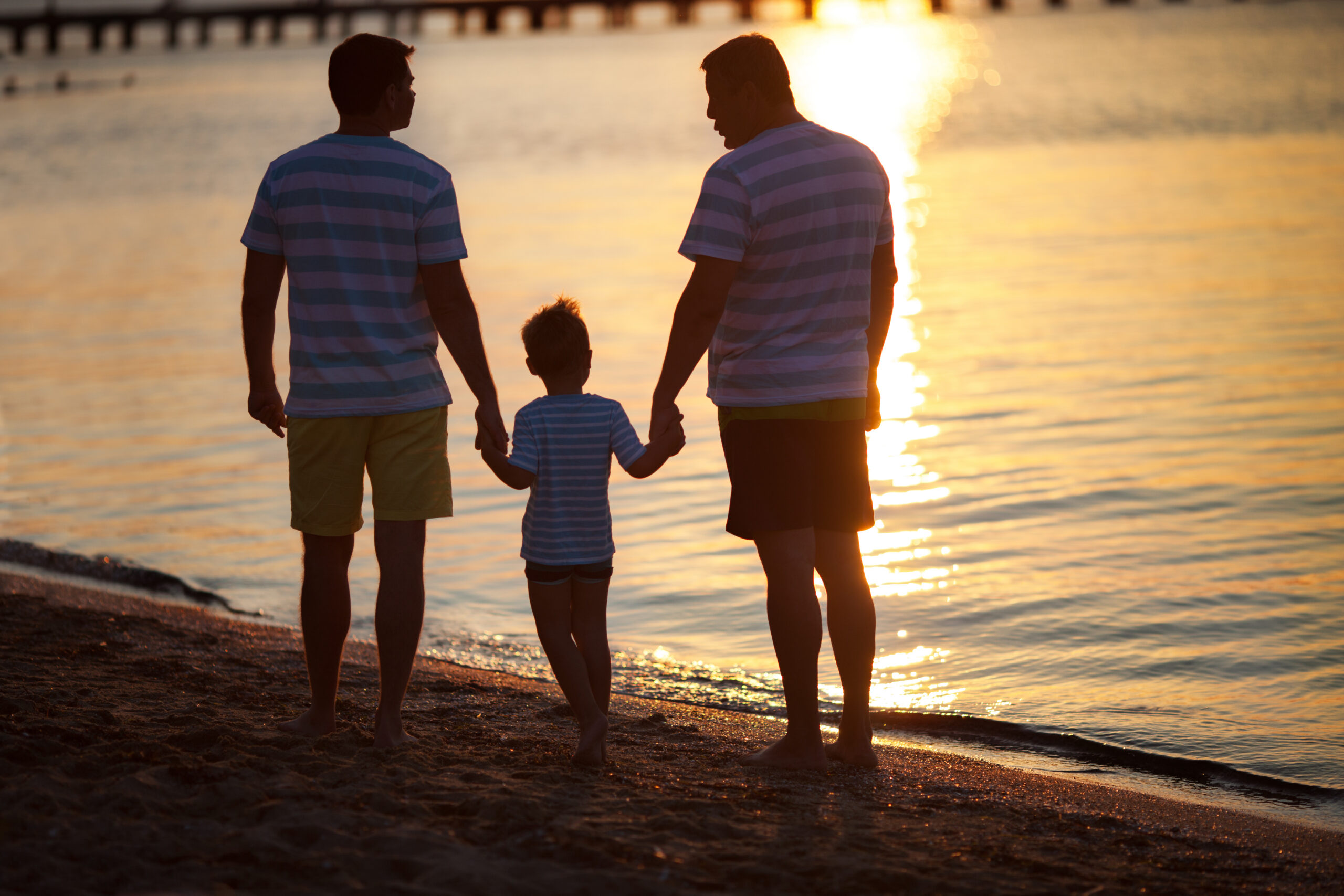 grandfather, son, and grandson walking on the beach in the golden isles